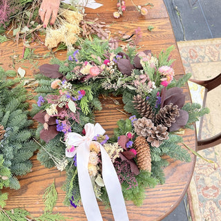 Dried floral winter wreath with evergreens and ribbon